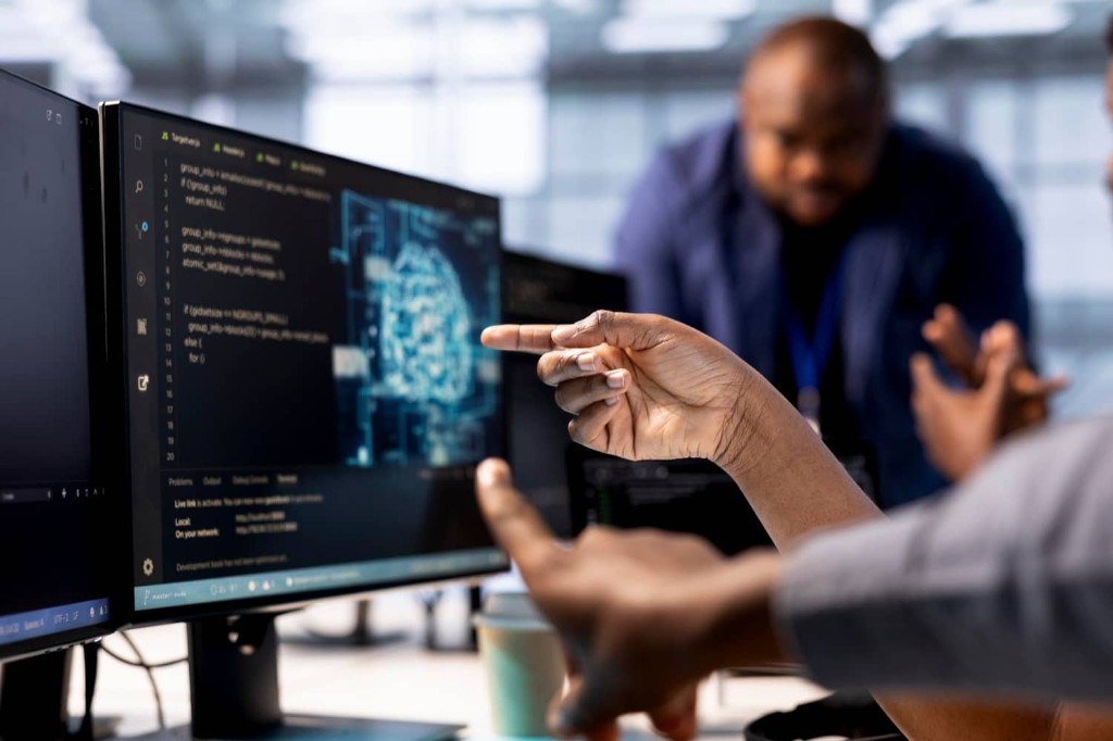 Team reviewing AI-related code and digital systems on a monitor together